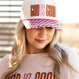 Cap with neutral crown, pink and brown checkered bill, and raised 3D embroidery reading ‘God Is Good’; features pink accent, contrast rope on the brim, and a snapback closure