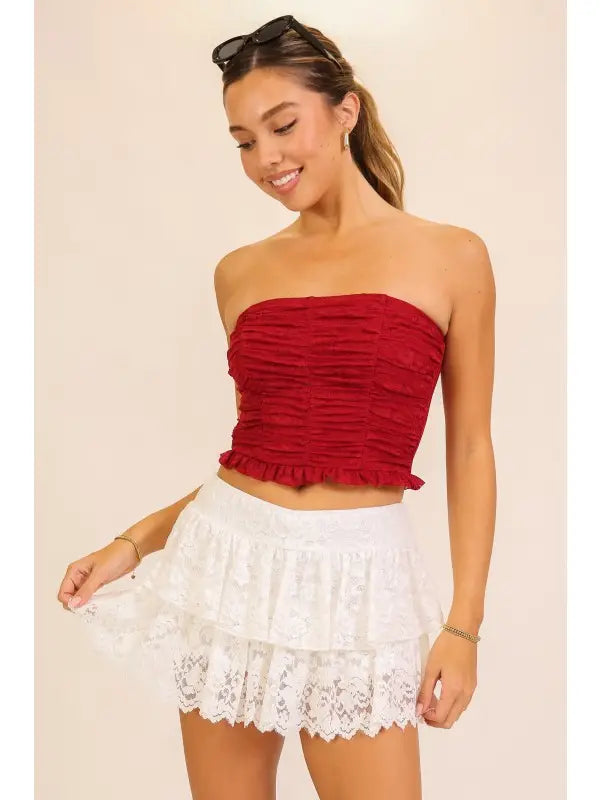 White lace mini skirt with layered lace and a flouncy hem, shown on a model