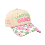 Cap with neutral crown, soft green and pink raised embroidery reading ‘Lead With Grace  and a floral gingham inspired brim