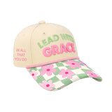 Cap with neutral crown, soft green and pink raised embroidery reading ‘Lead With Grace  and a floral gingham inspired brim