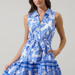 Luna Crest Floral Zady Sleeveless Mini Dress in two colors, floral pattern, collared neck, button front, belted waist, ruffle mini hem, styled with sun hat, mini bag, and flat sandals