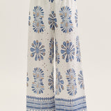 White pants with blue floral patterns worn by a person on a white background