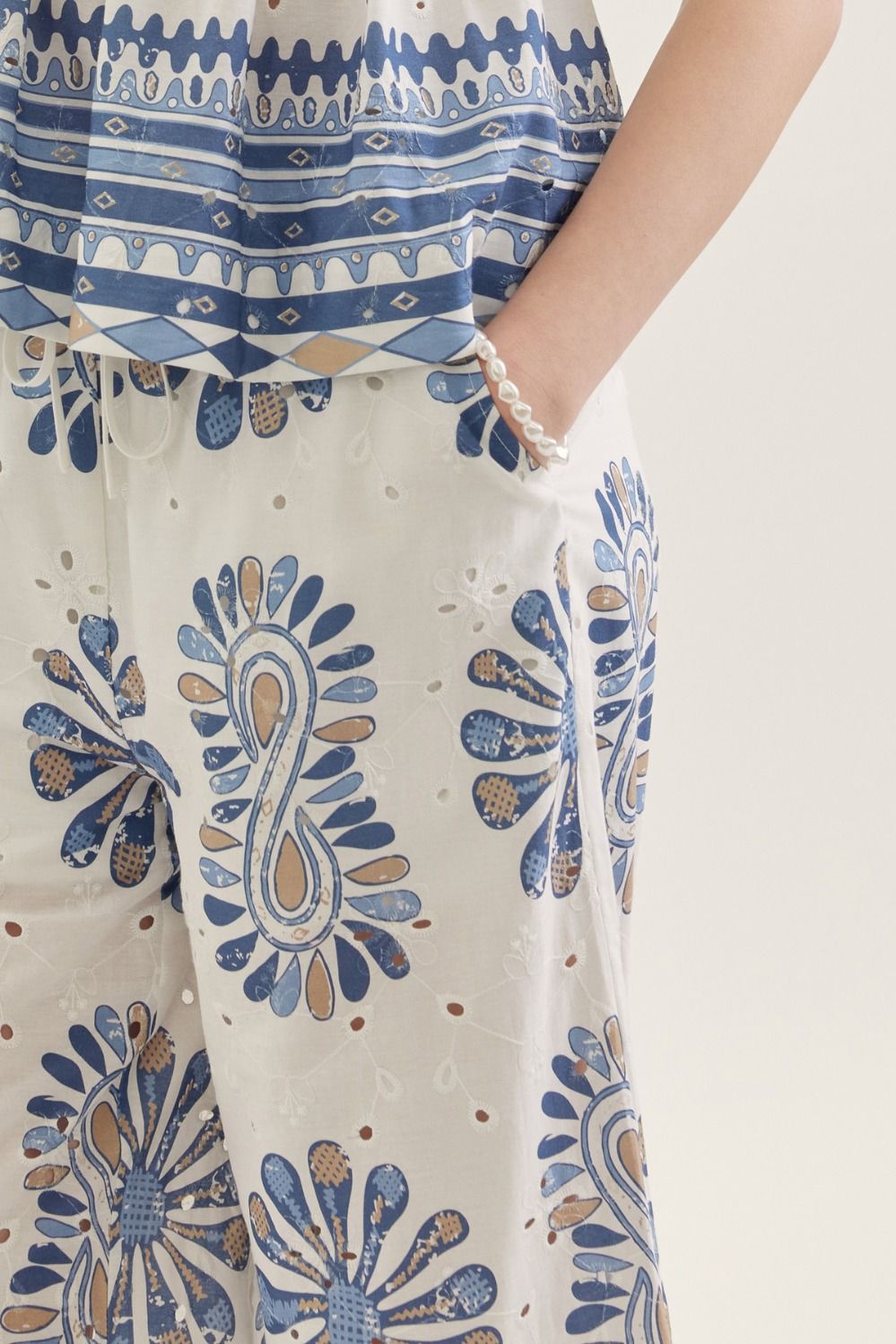 Close-up of a person wearing a blue and white patterned outfit with a focus on the pants.
