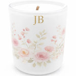 Candle with floral design and initials 'JB' on a white background