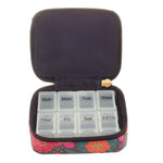 Weekly pill organizer with floral case on a white background