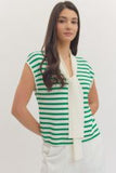Woman wearing a green and white striped sleeveless top with a plain background