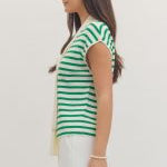 Woman wearing a green and white striped sleeveless top on a plain background