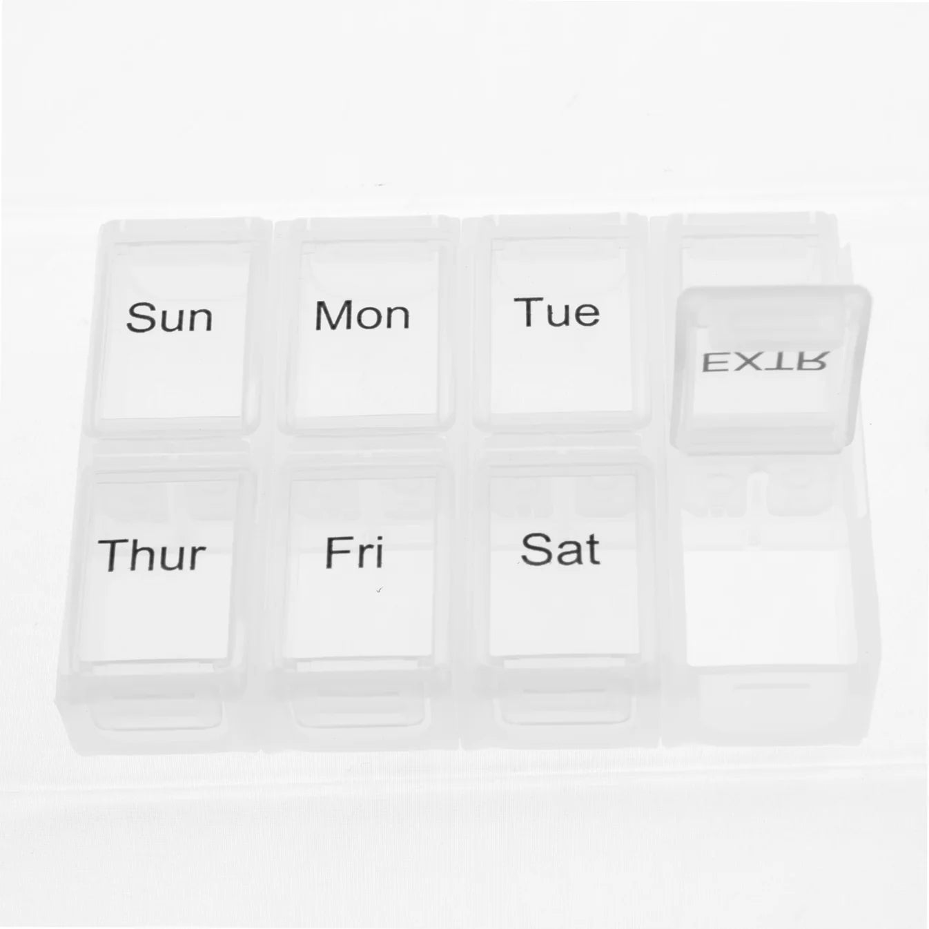 White pill organizer with days of the week labels on a white background