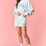 Woman wearing a tie-dye 'USA' outfit on a pink background