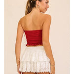 White lace mini skirt with layered lace and a flouncy hem, shown on a model