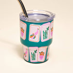 Teal tumbler with colorful designs on a beige background
