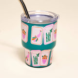 Teal tumbler with colorful designs on a beige background